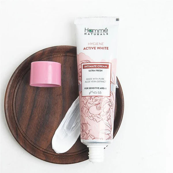 Hémè Naturals intimate cream tube on a wooden tray with a white background