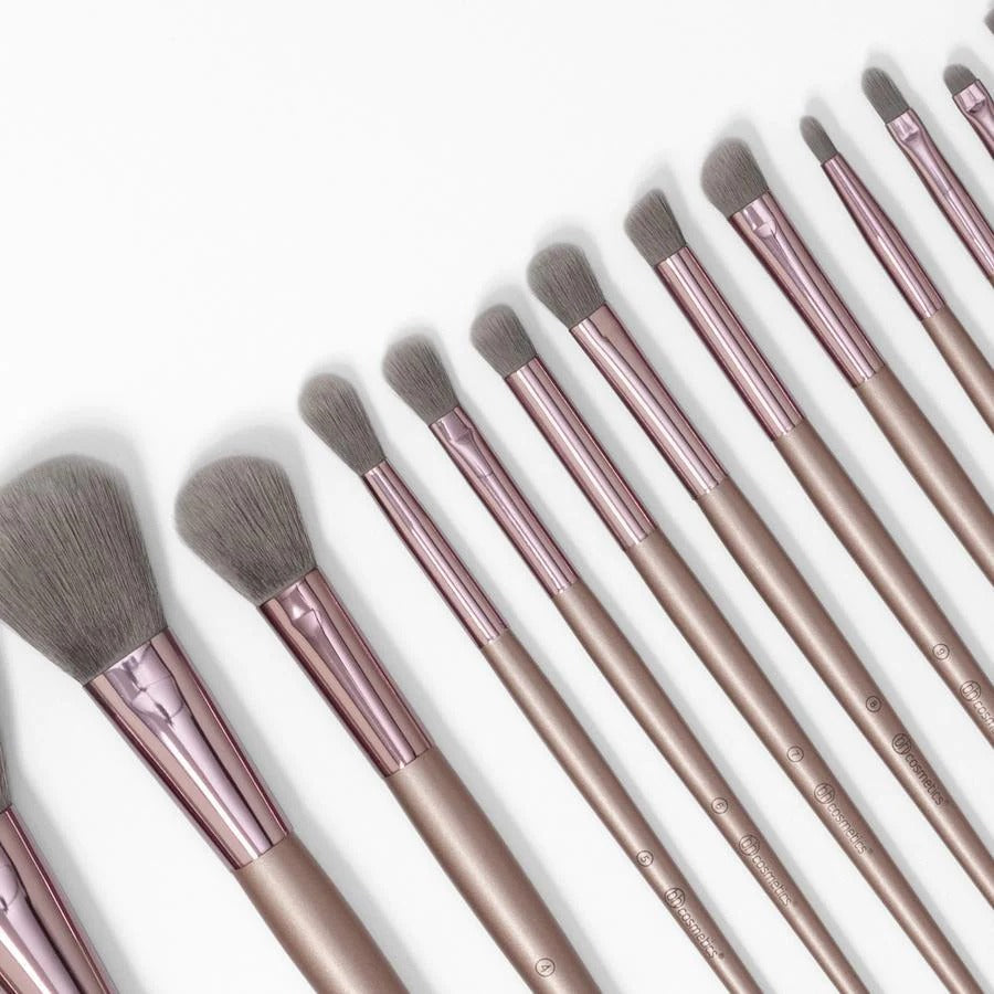 Set of makeup brushes with rose gold handles on a white background