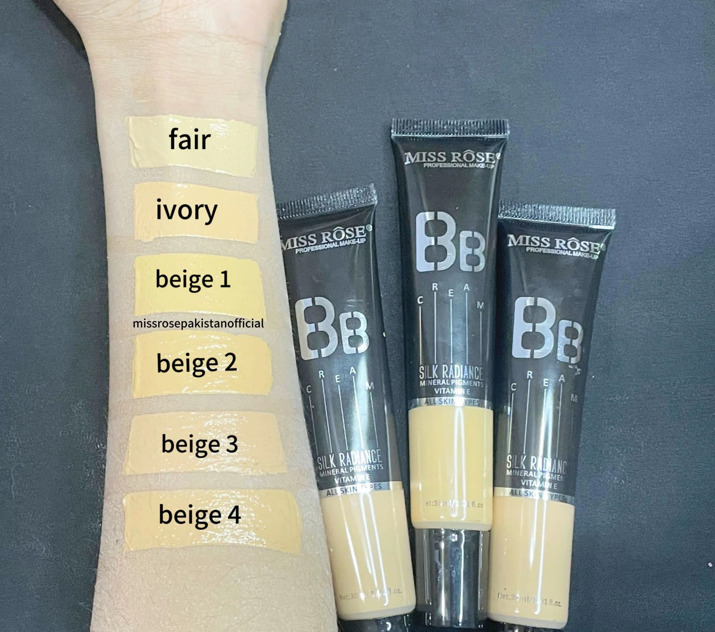 Miss Rose BB Cream tubes with color swatches on a arm against a dark background