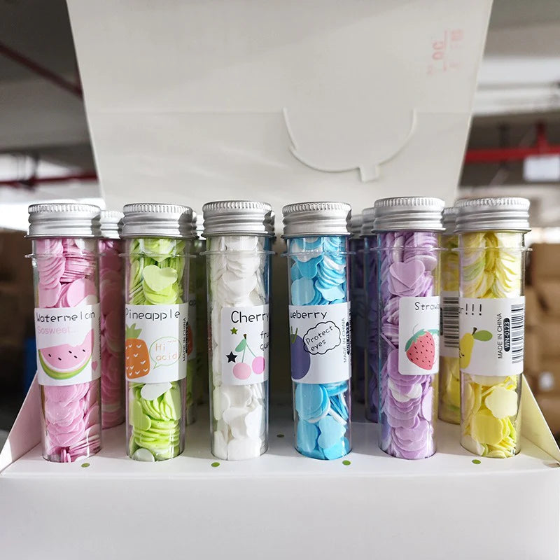 Colorful tubes with fruit-themed labels on a white surface