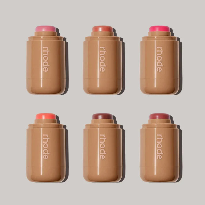 Six Rhode brand cosmetic sticks on a light gray background