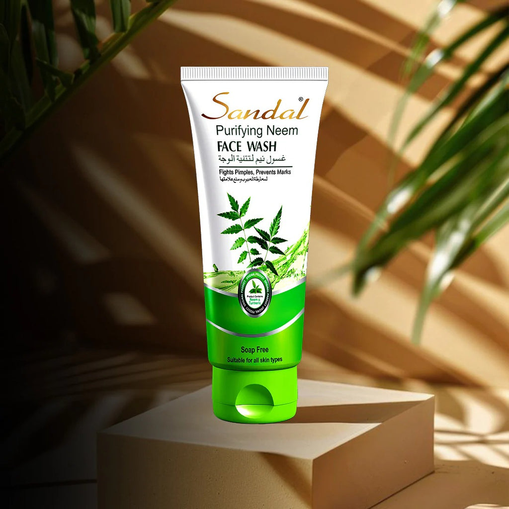 Tube of Sandal Purifying Neem Face Wash with green and white design on a beige platform with plant shadows.