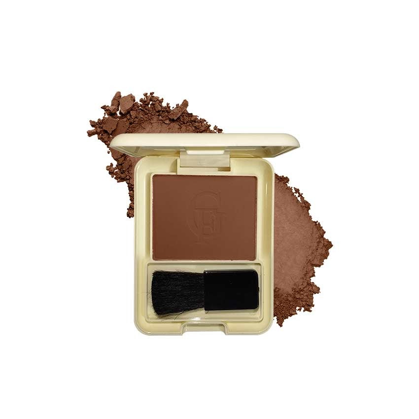 Compact brown powder with a brush and scattered powder on a white background