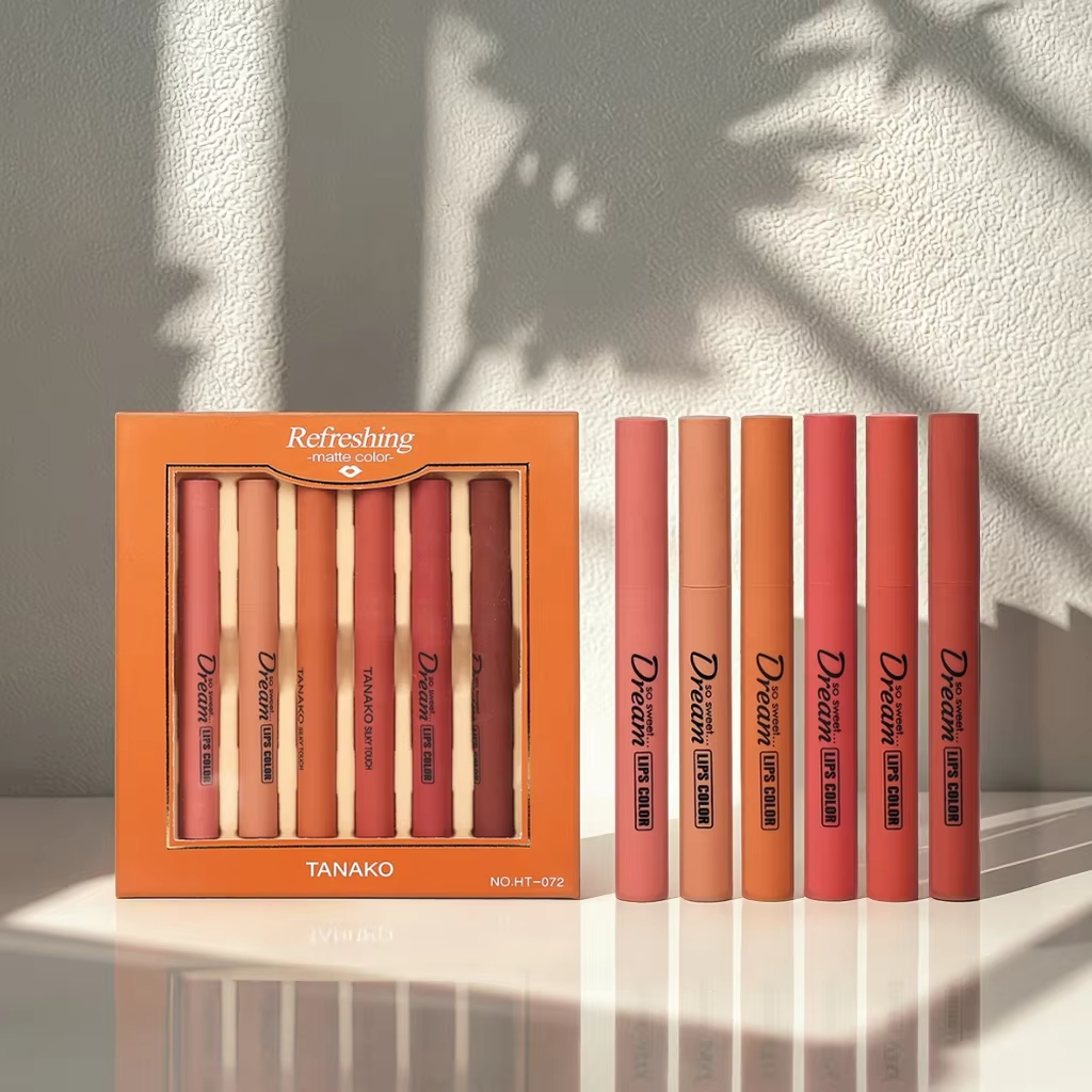 Set of lip pencils with an orange packaging box on a light background