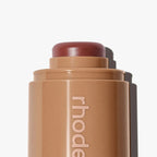 Cosmetic stick with 'rhode' branding on a white background