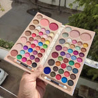 Makeup palette with various colors held by a hand outdoors