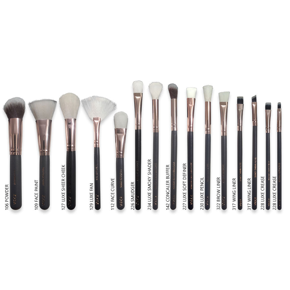 Set of makeup brushes with black handles and white bristles on a white background