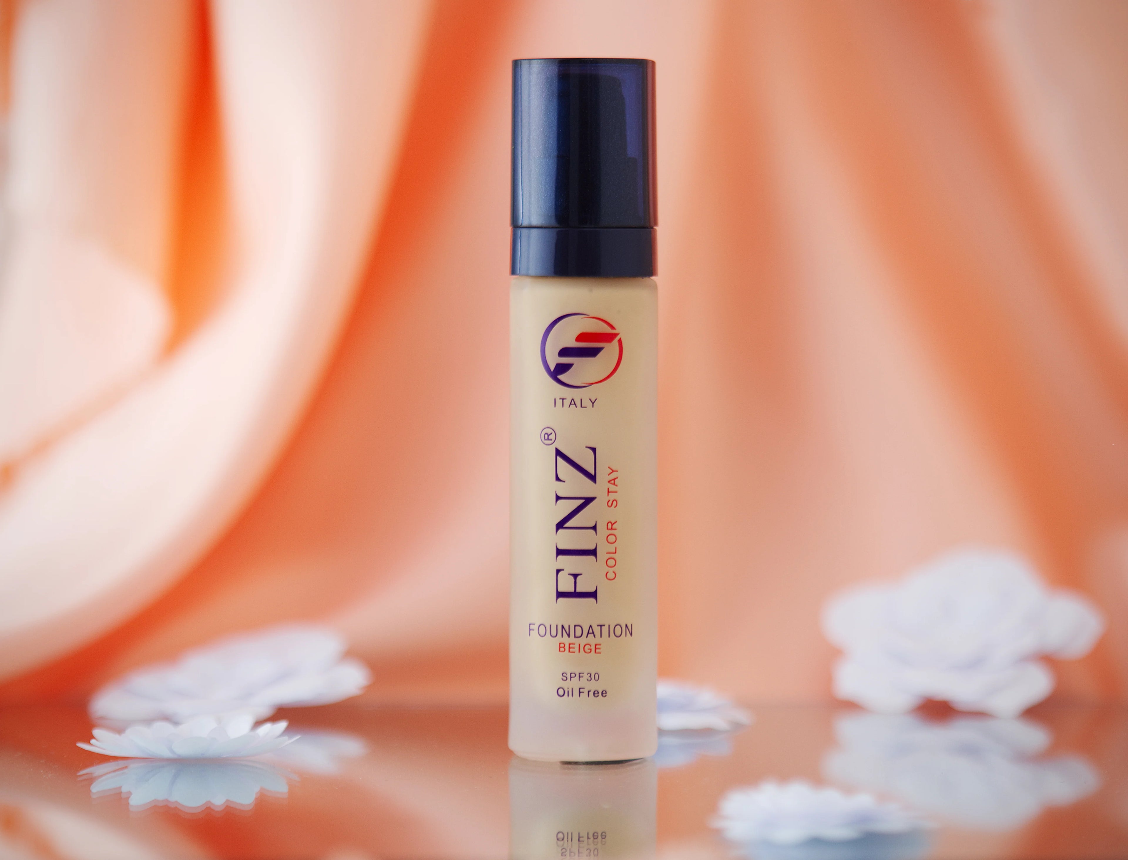Finz Color Stay Oil Free Liquid Foundation SPF 30 bottle with visible brand logo on a reflective surface with a blurred background